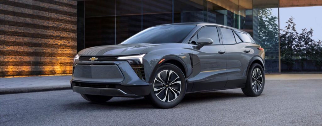 A grey 2024 Chevy Blazer EV is shown parked outside a building.