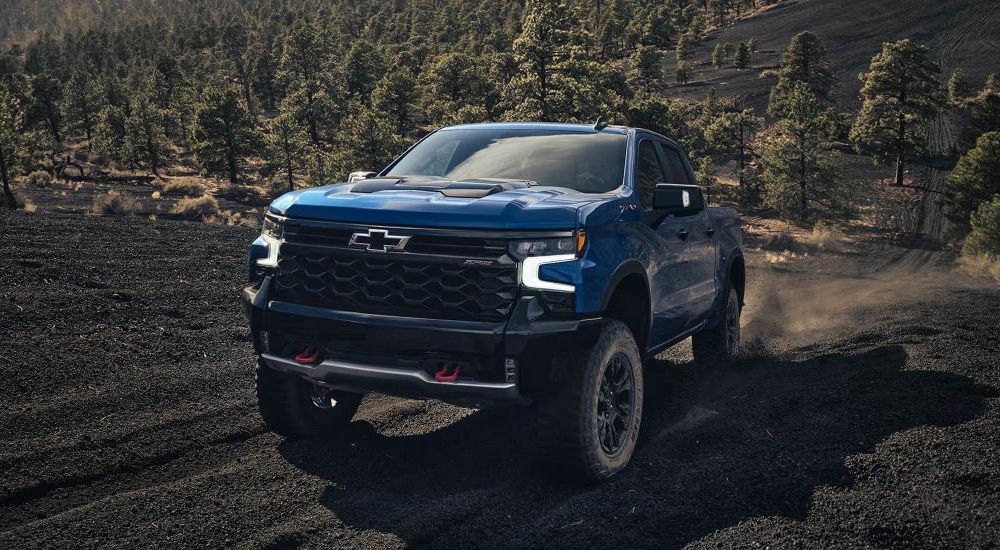 A popular Chevy Silverado for sale, a blue 2024 Chevy Silverado ZR2 is shown driving off-road.