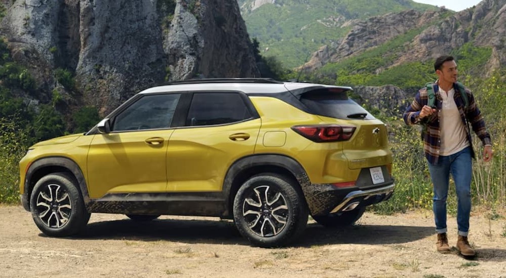 A person is shown walking near a yellow 2024 Chevy Trailblazer.