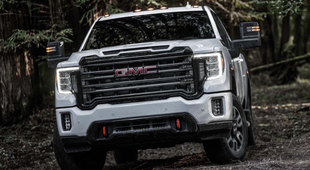 A white 2024 GMC Sierra 2500 HD AT4 is shown driving.