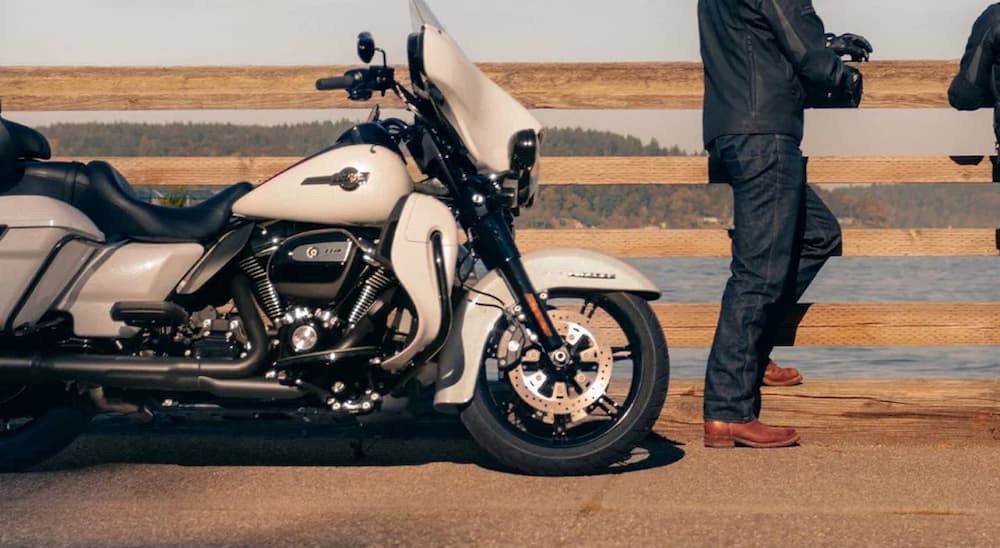 A white 2024 Harley-Davidson Ultra Limited is shown parked near a fence. 