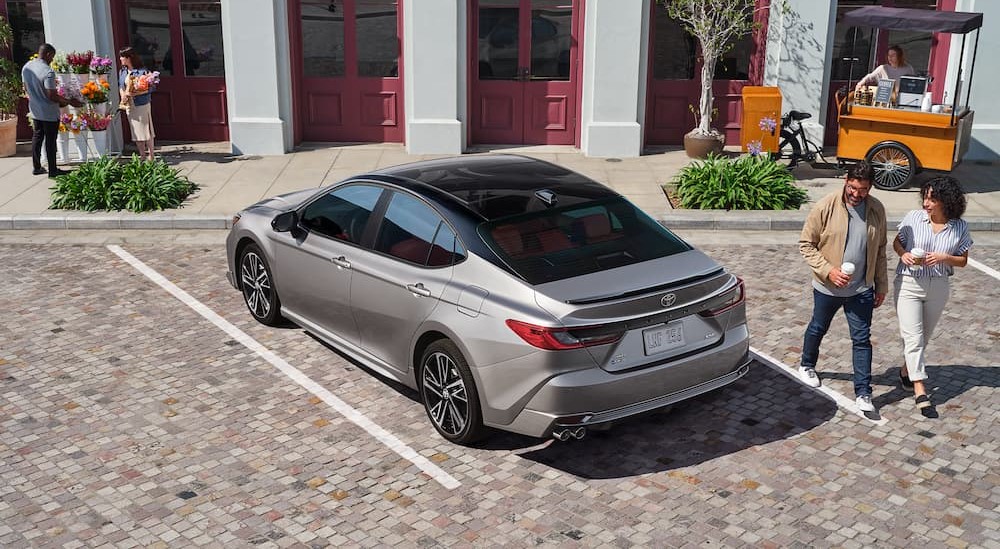 A silver 2025 Toyota Camry is shown parked on a parking spot.