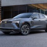 A grey 2024 Chevy Blazer parked in front of a modern home.