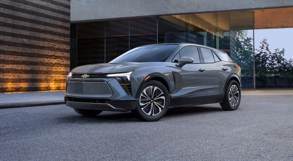 A grey 2024 Chevy Blazer parked in front of a modern home.