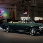 A green 1969 Chevrolet Corvair is shown parked in a garage.