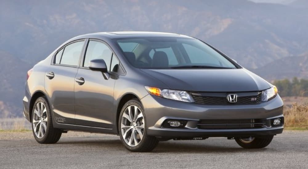 A gray 2013 Honda Civic SI is shown parked near a mountain.
