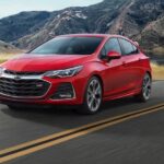 A red 2019 Chevy Cruze RS is shown driving on a highway after visiting a used Chevy dealership.