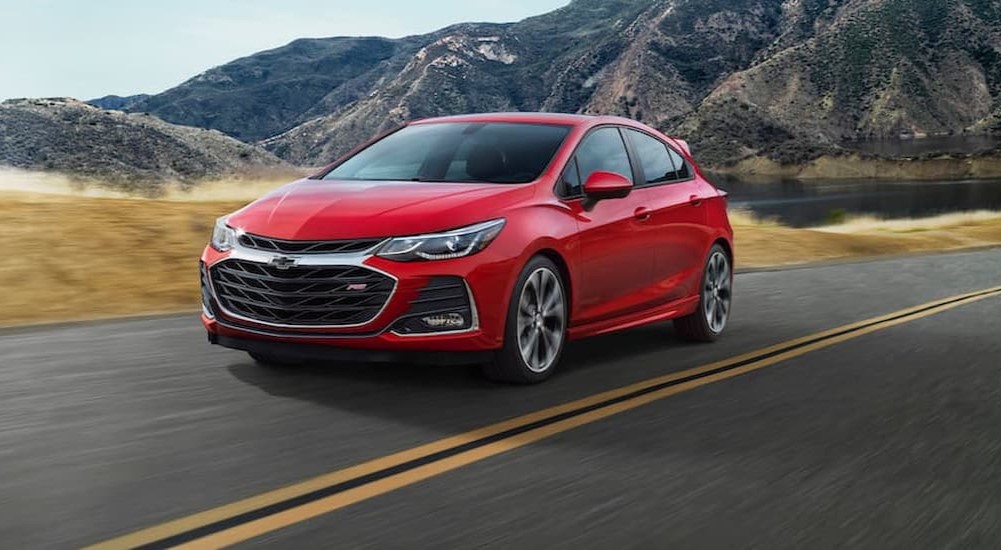 A red 2019 Chevy Cruze RS is shown driving on a highway after visiting a used Chevy dealership.