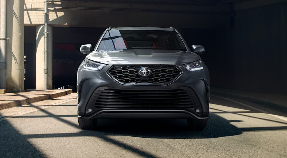 A gray 2021 Toyota Highlander is shown driving on a city street.