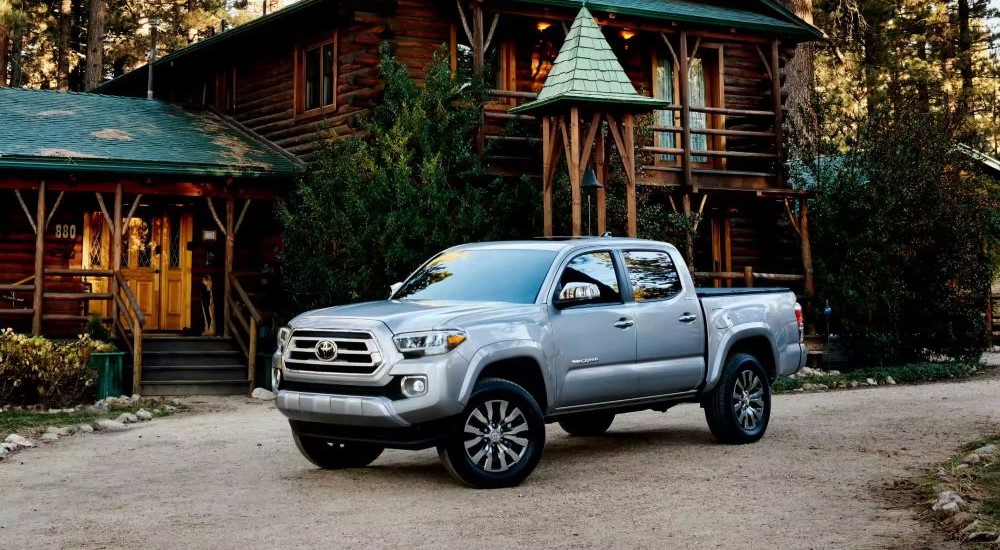 A silver 2023 Toyota Tacoma Limited is shown parked near a cabin.