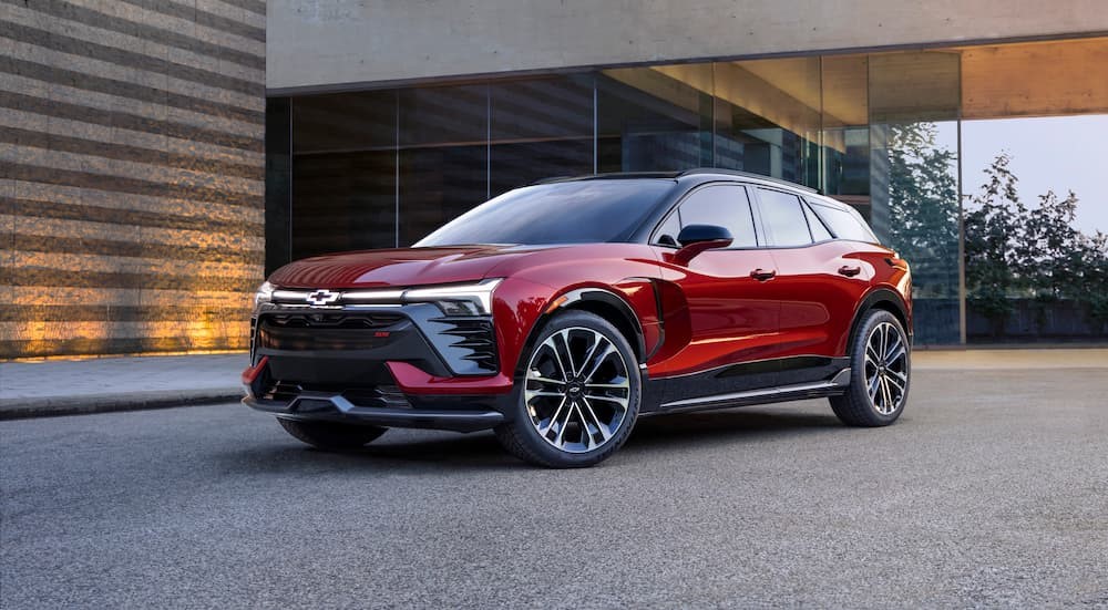 A red 2024 Chevy Blazer EV RS is shown parked beside a building.