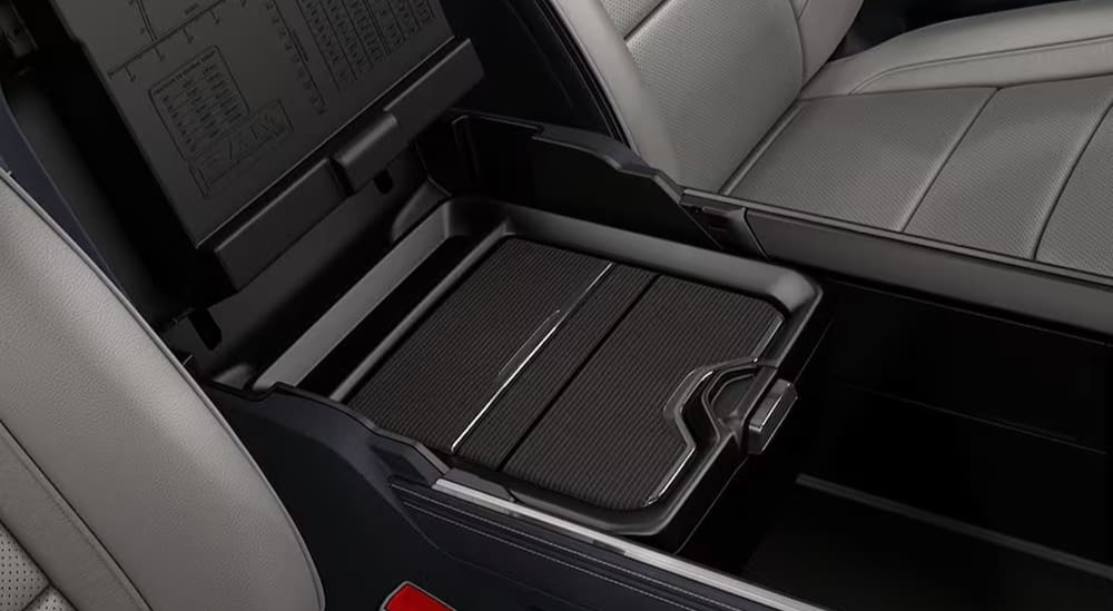 A close-up of the black reconfigurable center console is shown in the interior of a 2024 Ram 1500.