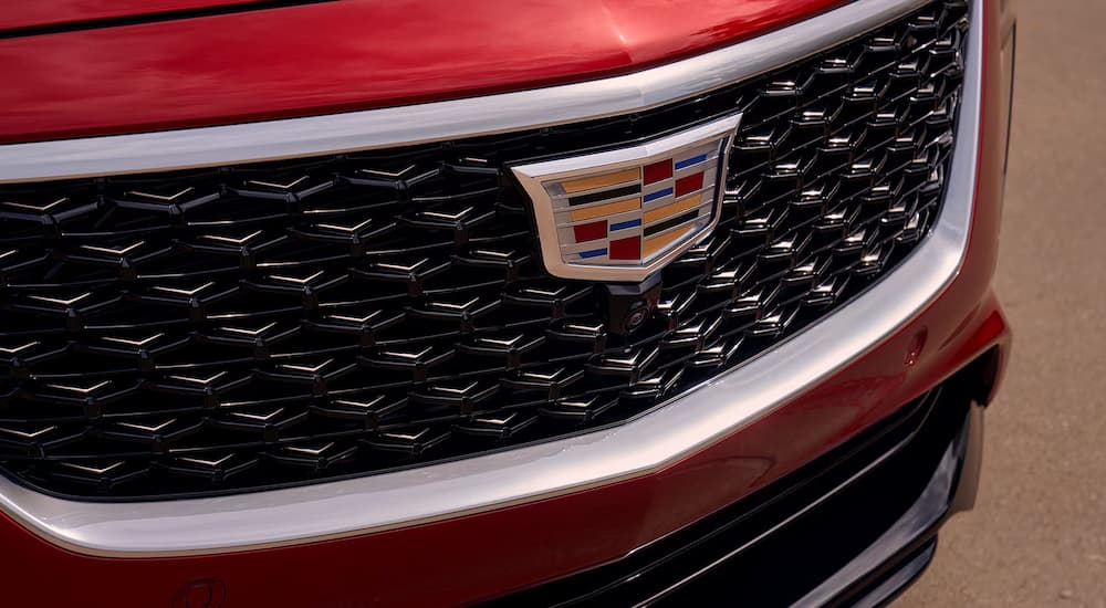 A close-up of the grille and Cadillac badge on a red 2025 Cadillac CT5.