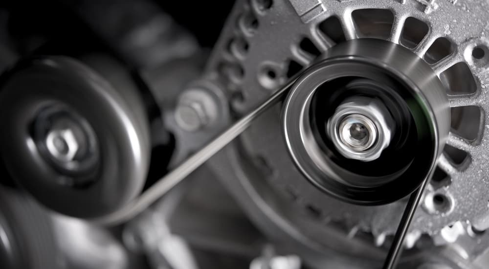 A close-up of a car alternator is shown.