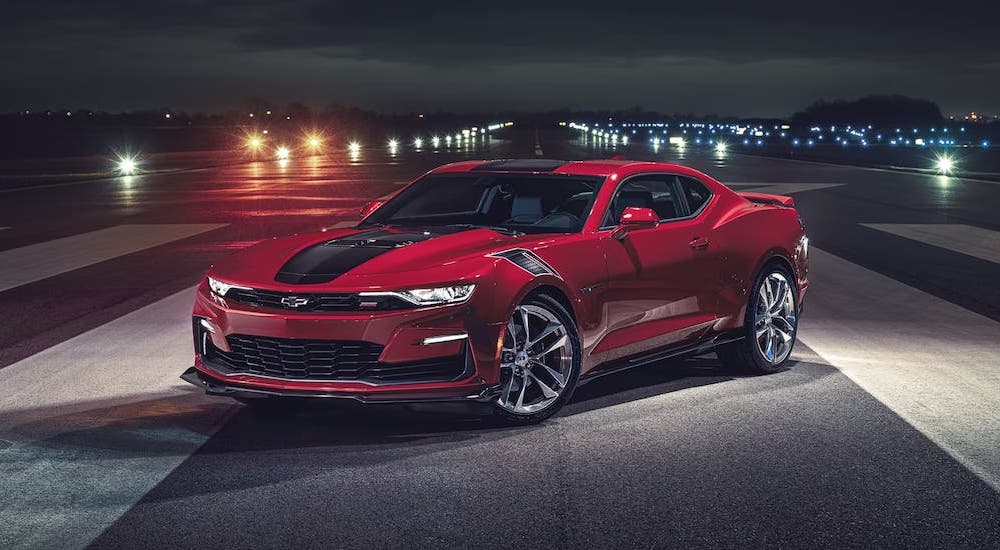 A red 2024 Chevy Camaro is shown parked at a side angle.