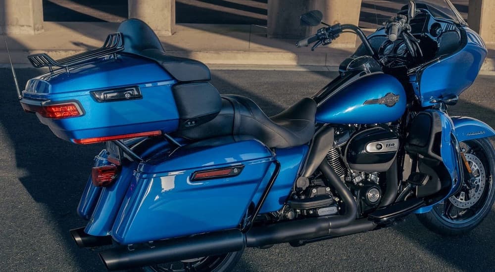 A blue 2024 Harley-Davidson Road Glide is shown parked at a Harley-Davidson dealer.
