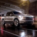 A silver 2023 Ford F-150 Lightning is shown driving in a tunnel after visiting a NV Ford EV dealer.