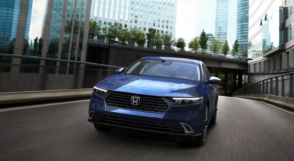 A blue 2024 Honda Accord driving through the city.