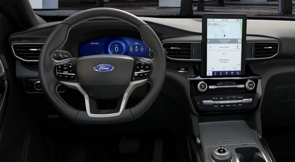 A close-up of the steering wheel and infotainment screen in a 2024 Ford Explorer is shown.