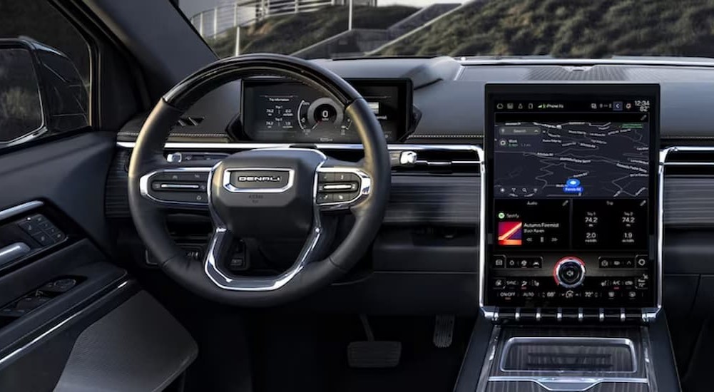 The steering wheel and large infotainment screen in a 2024 GMC Sierra EV Denali Edition 1.