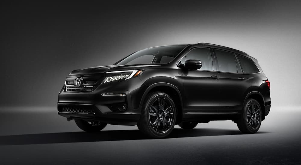 A black 2020 Honda Pilot is shown parked in a shaded room.