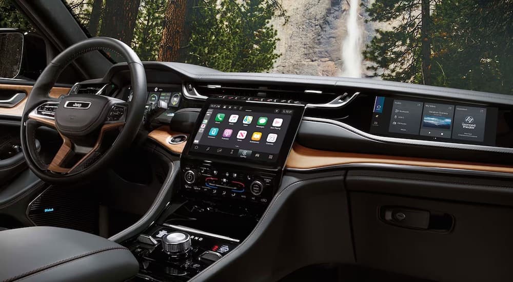 The black interior of a 2024 Jeep Grand Cherokee is shown from the passenger seat.