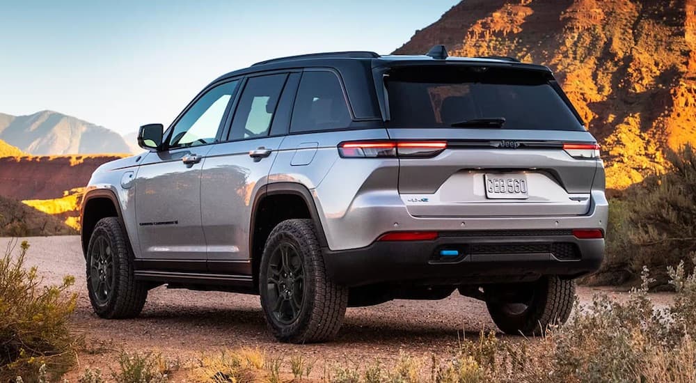 A silver 2024 Jeep Grand Cherokee 4xe is shown from the rear at an angle.