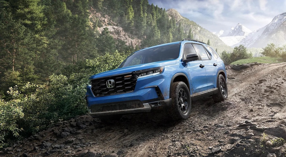 A blue 2025 Honda Pilot TrailSport is shown from the front at an angle after leaving a Honda dealer.