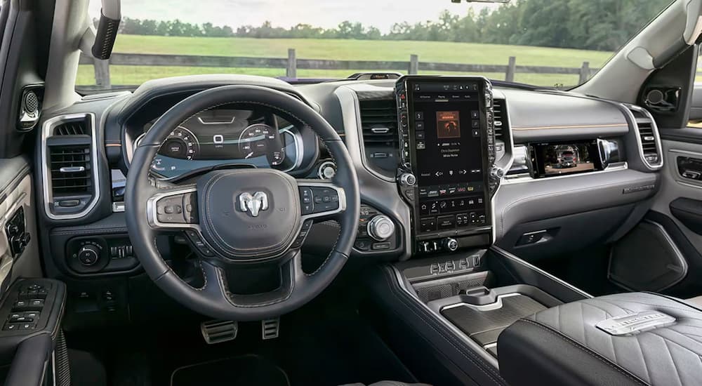 A close up of the steering wheel and center console of a 2025 Ram 1500 Tungsten.