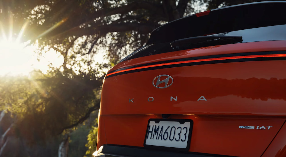 The Hyundai and Kona badges on the back of a red 2024 Hyundai Kona Limited.