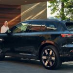 A black 2024 Honda Prologue Elite is shown being charged near a Honda dealer.
