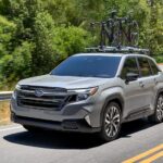 A grey 2025 Subaru Forest driving down a winding road.