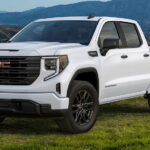 A white 2024 GMC Sierra 1500 Pro parked off-road and angled left.