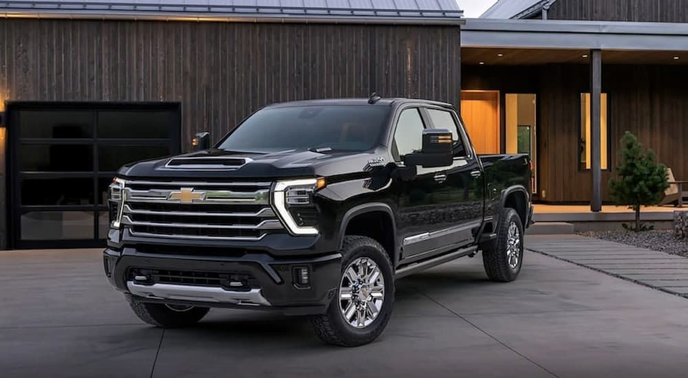 A popular Chevy Silverado 2500 for sale, a black 2024 Chevy Silverado 2500 HD High Country, is shown parked on a driveway.