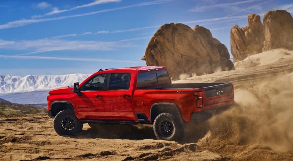 A red 2025 Chevy Silverado 2500 ZR2 Bison is shown off-roading.