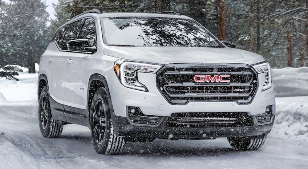 A white 2021 GMC Acadia is shown from the front at an angle.