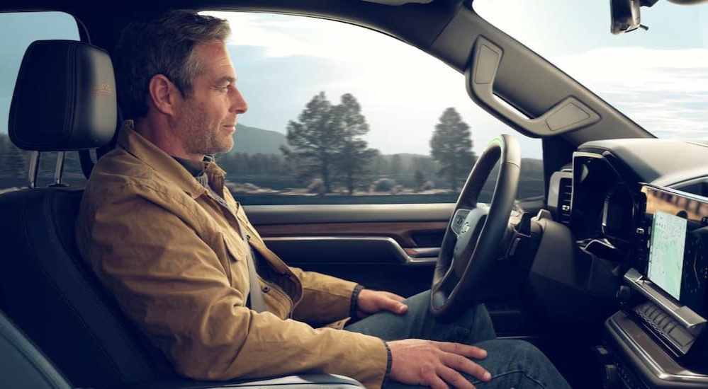 A person is shown using SuperCruise technology in a 2025 Chevy Silverado 1500 High Country.