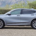 A silver 2025 Buick Envista Avenir is shown parked on gravel.