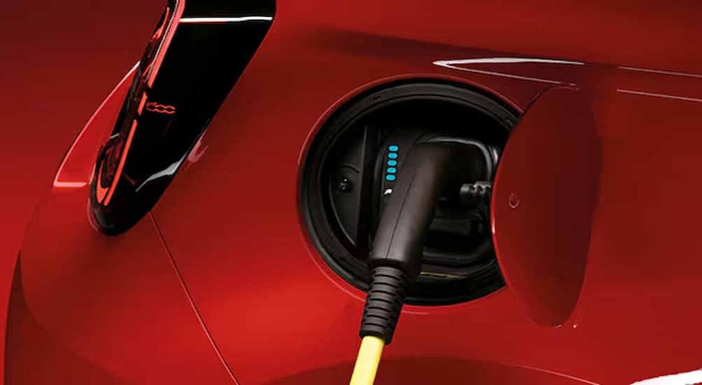 A red 2024 FIAT 500e is shown charging.