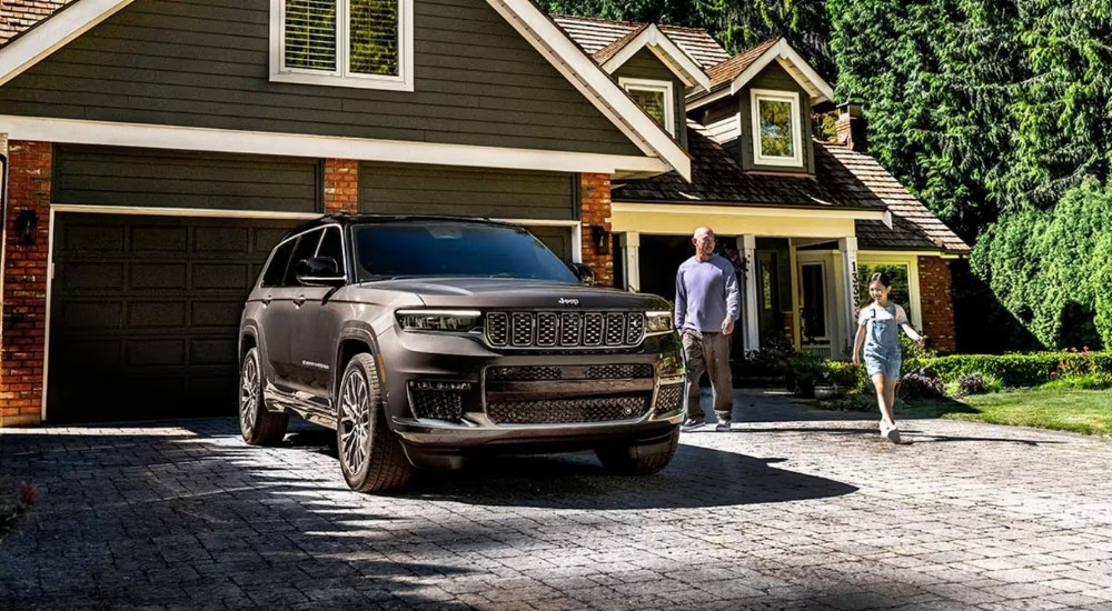 A grey 2025 Jeep Grand Cherokee for sale is shown from the front at an angle.