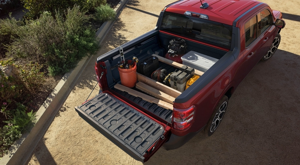 The bed of a red 2025 Ford Maverick full of landscaping supplies.