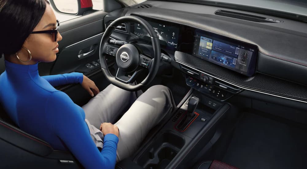 Woman driving in a 2025 Nissan Kicks SR.