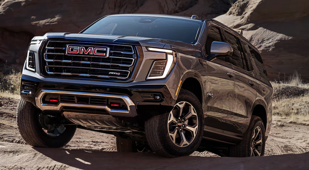 A grey 2025 GMC Yukon AT4 driving off-road.