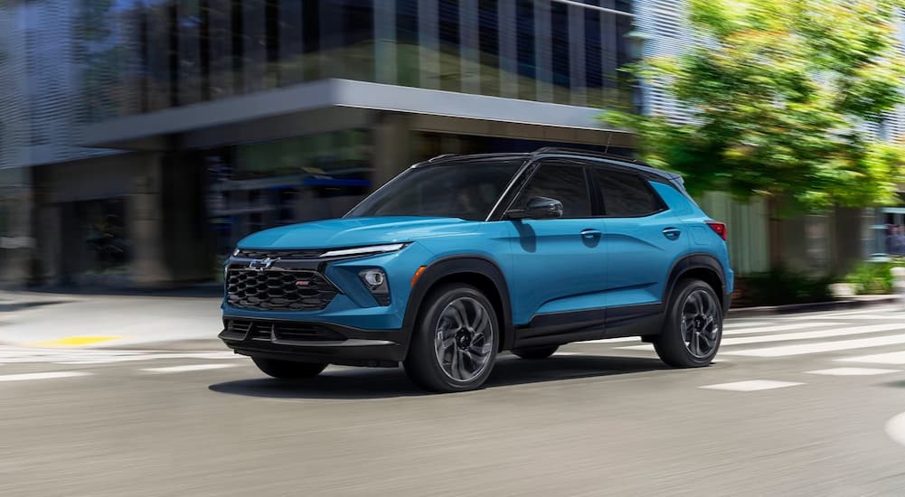 A blue 2025 Chevy Trailblazer RS driving to a Chevy dealer.