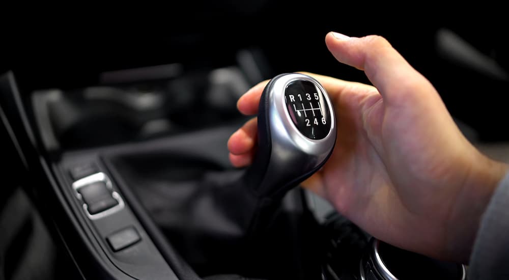 A hand using a gear shift knob on manual transmission vehicle