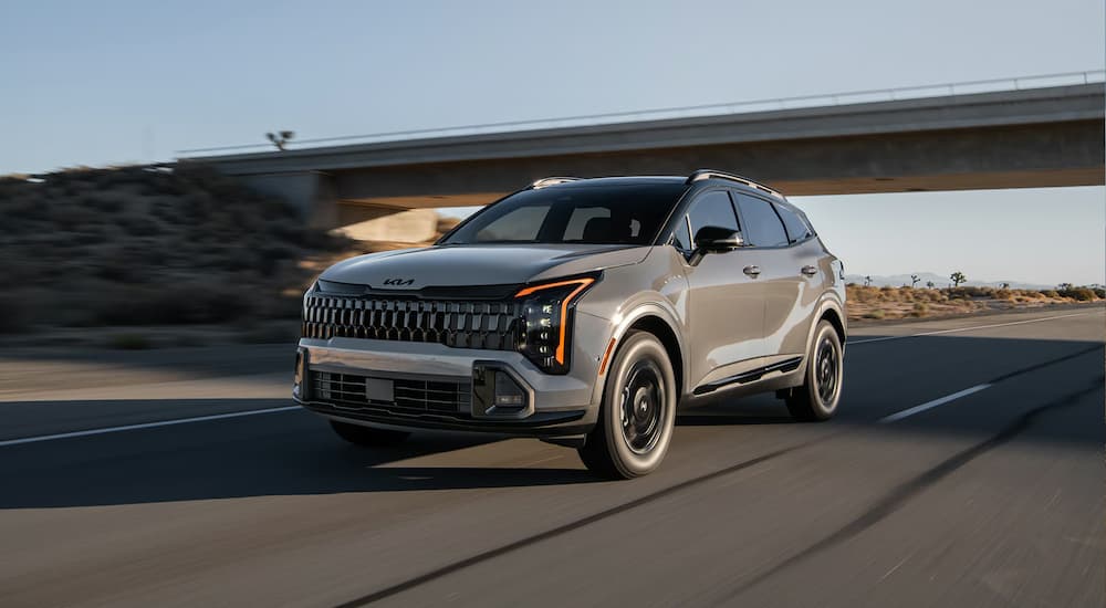 Gray 2025 Kia Sportage for sale driving down highway