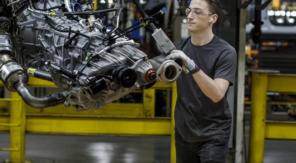 A man in a Ford plant putting a vehicle together