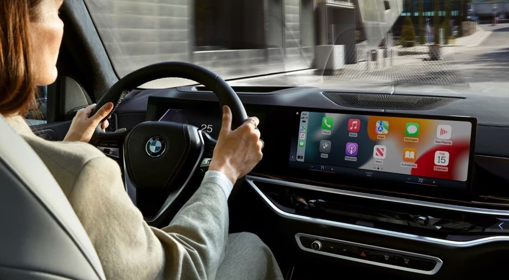 A woman driving a used 2024 BMW X5 for sale