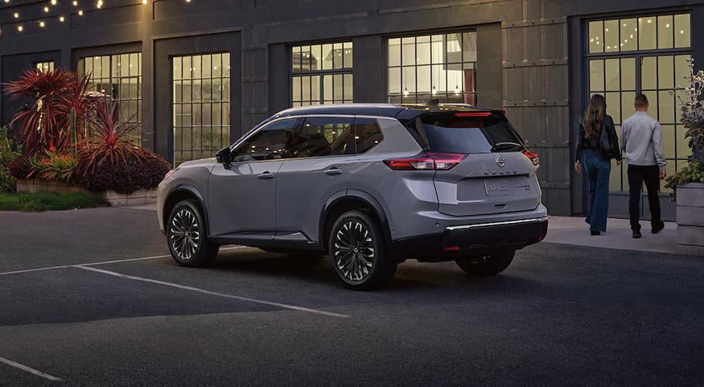 A silver 2025 Nissan Rogue parked outside a building at night