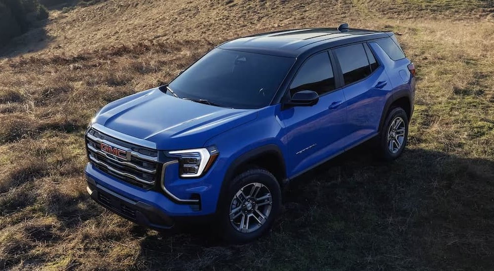 A blue 2026 GMC Terrain Elevation parked on grass.